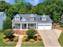 Charming home with a manicured lawn, a two-car garage, and a welcoming front porch at 10809 Grassy Creek Pl, Raleigh, NC 27614