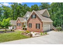 Beautiful two-story brick home with manicured lawn and charming landscaping at 1084 Wild Briar Ln, Stem, NC 27581