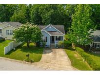 Charming blue single-story home with a well-manicured lawn, mature landscaping, and a concrete driveway at 1138 Ricochet Dr, Raleigh, NC 27610