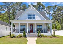 Charming two-story home with a welcoming front porch, red door, and lush lawn at 1230 S 2Nd St, Smithfield, NC 27577