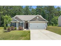 Charming single-story home with a well-manicured lawn, two-car garage, and welcoming front entrance at 145 Bounding Ln, Youngsville, NC 27596