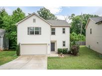 Charming two-story home featuring an attached garage, landscaping, and neutral color scheme at 157 Lynn Dr, Clayton, NC 27520