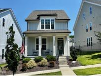 Charming two-story home with a cozy front porch, landscaped yard, and a delightful curb appeal at 1705 Main Divide Dr, Wake Forest, NC 27587