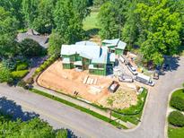 Expansive aerial view of a modern home under construction, surrounded by lush greenery at 1925 Hunting Ridge Rd, Raleigh, NC 27615