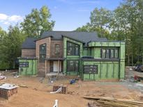 Modern two story home featuring brick and green sheathing under construction at 1925 Hunting Ridge Rd, Raleigh, NC 27615