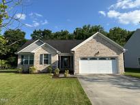 Charming brick home with a well-manicured lawn and an attached two-car garage at 201 Joe Gibson Dr, Gibsonville, NC 27249