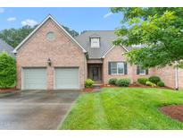 Charming brick home with a well-manicured lawn and a two-car garage at 2012 Muirfield Ct, Elon, NC 27244