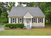 Charming tan home with a cozy front porch, dark shutters and well-maintained landscaping at 2708 Sundial Cir, Durham, NC 27704