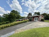 Charming single-story home with siding, double doors, concrete driveway, and lush landscaping at 2909 Sprucewood Dr, Durham, NC 27707
