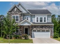 Charming two-story home showcasing a stone and siding exterior, lush landscaping, and a welcoming two-car garage at 359 Abbot Pl, Chapel Hill, NC 27516