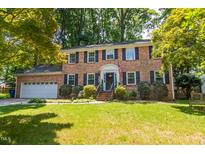 Charming two-story brick home with attached garage and a lush, landscaped front yard at 4200 Marvin Pl, Raleigh, NC 27609