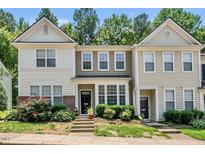 Two-story townhome with neutral siding, black front door, and well-maintained landscaping with mature flowering bushes at 4353 Sugarbend Way, Raleigh, NC 27606