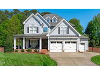 Charming two-story home featuring a three-car garage, inviting front porch, and well-maintained landscaping at 6004 Brass Tack Ct, Fuquay Varina, NC 27526