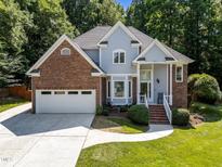 Inviting two-story home featuring a brick and siding facade, well-manicured lawn, and attached two-car garage at 7605 Pats Branch Dr, Raleigh, NC 27612