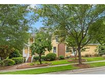 Charming yellow two-story home featuring a brick chimney, manicured lawn, and welcoming front porch at 800 Highgrove Dr, Chapel Hill, NC 27516