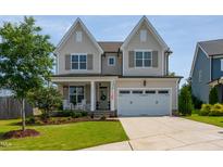 Charming two-story home with a well-manicured lawn, inviting porch, and a two-car garage at 857 Mill Station Ln, Wendell, NC 27591