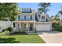 Charming two-story home with a welcoming front porch and well-maintained lawn and an attached two-car garage at 908 Town Side Dr, Apex, NC 27502