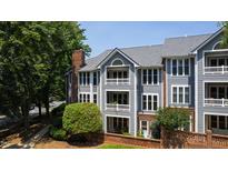 Beautiful three-story condo building featuring gray siding, white trim, and brick accent wall at 911 Washington St # 304, Raleigh, NC 27605