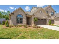 Charming brick home featuring an attached two-car garage and well-manicured lawn at 1041 Bonanza Ln # 37, Mebane, NC 27302