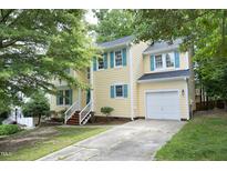 Charming two-story home with a well-maintained lawn and a paved driveway leading to a single-car garage at 105 Old Dock Trl, Cary, NC 27519