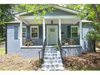 Charming home featuring a cozy front porch with seating and beautiful gray exterior with teal shutters at 120 Pine St, Carrboro, NC 27510