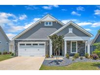 Charming home showcasing stone accents, gray siding, a manicured lawn, and a two-car white garage at 1217 Linkwood Way, Fuquay Varina, NC 27526