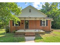 Charming brick home featuring a cozy front porch and traditional design at 1411 Hudson Ave, Durham, NC 27705
