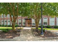 Beautiful brick building with trees lining the walkway and benches in front at 1535 Caraleigh Mills Ct # 210, Raleigh, NC 27603