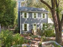 Charming two-story home with a landscaped front yard and garden, featuring white trim and a welcoming entrance at 1605 Valley Run, Durham, NC 27707