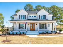 Charming two-story modern farmhouse featuring a welcoming front porch and beautifully landscaped front yard at 162 Farmstead Ct, Wendell, NC 27591