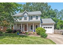 Charming two-story home with a covered front porch, lush landscaping, and an attached two-car garage at 19 Knightsbridge Ct, Durham, NC 27707