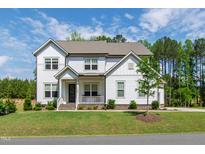 Charming two-story home with a manicured lawn and a welcoming front porch, perfect for enjoying the outdoors at 1928 Vandiver Way, Apex, NC 27523