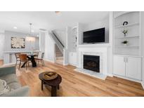 Bright living room features a fireplace, built-in shelving, and a dining area with light wood flooring at 2040 Persimmon Ridge Dr, Raleigh, NC 27604