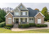 Charming home featuring a stone and siding facade, inviting front porch, and well-manicured lawn at 2100 Stone Pasture Rd, Fuquay Varina, NC 27526