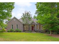 Charming brick home featuring a well-manicured lawn and mature trees at 2312 Shallowford Ln, Chapel Hill, NC 27517