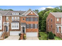 Charming brick townhome features a well-manicured lawn, attached garage and decorative shutters at 2740 Laurelcherry St, Raleigh, NC 27612