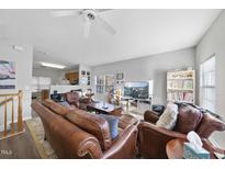 Comfortable living room features leather furniture, a ceiling fan, and lots of natural light at 2910 Barrymore St # 100, Raleigh, NC 27603