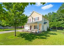 Charming two-story home featuring a landscaped yard, rocking chair front porch and attached two-car garage at 303 Sylvias Ct, Durham, NC 27703