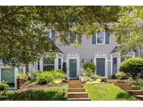 Charming townhomes featuring beautiful landscaping, front steps and gray siding at 318 Silverberry Ct, Cary, NC 27513