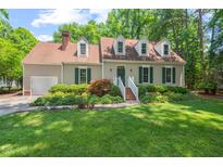 Charming single-Gathering home with lush green lawn, mature landscaping, and dormer windows at 3806 Lochnora Pkwy, Durham, NC 27705
