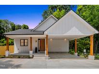 Charming white home featuring a covered carport, stone accents, and natural wood pillars at 411 Bon Air Ave, Durham, NC 27704