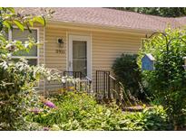 Charming home entrance with vibrant flowers and a cozy aesthetic, featuring a decorative birdhouse at 5911 Westcreek Pl, Raleigh, NC 27606