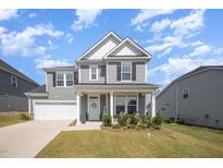 Beautiful two-story home with gray siding, white trim, and a well-manicured lawn at 645 Longstanton Ave, Zebulon, NC 27597