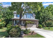 Charming two-story home featuring stone accents, a covered porch, and a well-manicured front yard at 6509 Conaway Ct, Wake Forest, NC 27587