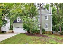 Charming two-story home with a lush green lawn and attached two car garage at 709 Bonhurst Dr, Holly Springs, NC 27540