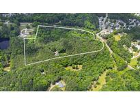 Aerial view of heavily wooded lot outlined in white with limited clearing for house at 7104 Camp Branch Ln, Apex, NC 27502