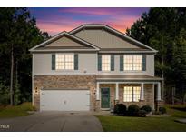 Charming two-story home showcasing stone accents, green shutters, and a well-manicured lawn at 98 Panmure, Rocky Mount, NC 27804