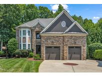 Beautiful stone home with a two-car garage and manicured lawn at 104 Bellagio Dr, Apex, NC 27539