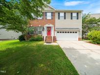 Charming home with brick and siding, a well-manicured lawn, and a bright red front door at 1209 Partington St, Wake Forest, NC 27587