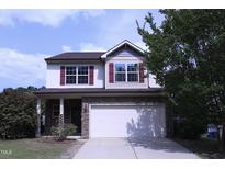 Charming two-story home with stone accents, attached two car garage, and well-manicured lawn at 126 Willow Weald Ct, Fuquay Varina, NC 27526